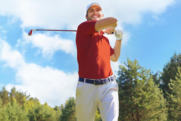 Jogador de golfe que bate o tiro de golfe com o clube no curso quando em férias de verão