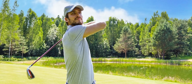 Jogador de golfe que bate o tiro de golfe com o clube no curso quando em férias de verão