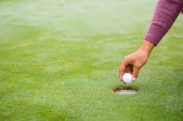 Jogador de golfe tentando jogar a bola no buraco