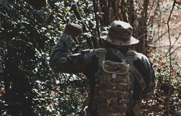 Foto jogador de jogo militar de airsoft em uniforme de camuflagem com rifle de assalto armado