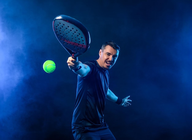 Jogador de padel tennis open tour homem atleta com raquete de padel tenis em fundo preto conceito esportivo