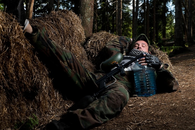 Jogador de paintball descansando no chão