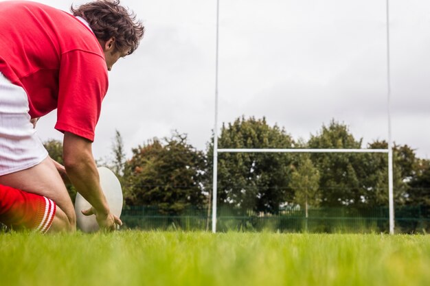 Foto jogador de rugby se preparando para chutar bola