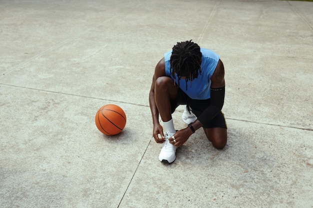 Jogador de streetball amarrando atacadores