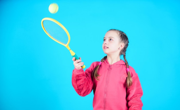 Jogador de tênis com raquete e bola atividade infantil criança feliz jogando tênis ginásio treino de adolescente menina dieta de fitness traz saúde e energia atividade de jogo esportivo infância feliz