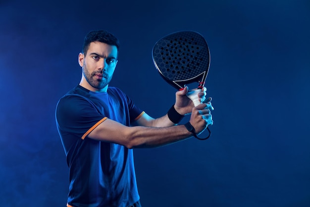 Jogador de tênis de pádel Atleta com raquete de tênis a pádel em fundo de néon Conceito esportivo Baixe uma foto de alta qualidade para o site de esportes