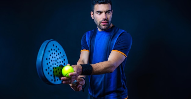 Foto jogador de tênis de padel com raquete atleta com raquete de padel em fundo preto conceito esportivo baixe uma foto de alta qualidade para o site de esportes