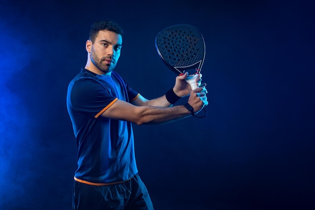 Jogador de tênis de padel com raquete Atleta com raquette de padel na quadra com cores de néon Conceito esportivo Baixe uma foto de alta qualidade para o design de um aplicativo de esportes ou site de apostas