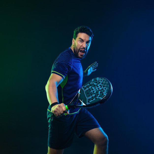 Jogador de tênis de padel emocional com raquete na mão paddle tenis em um download de fundo azul em alta