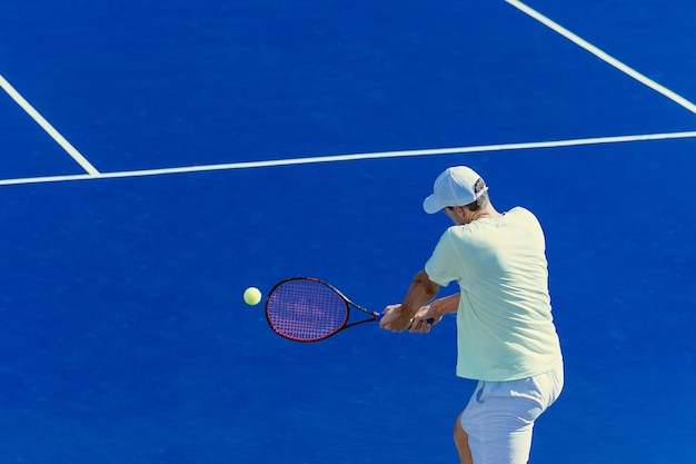 Jogador de tênis na quadra azul
