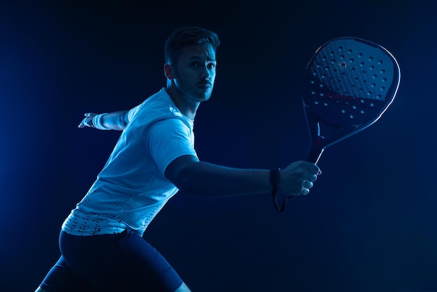Jogador de tênis Padel Padel open tour Atleta com raquete de tênis padel e bola em fundo azul Conceito esportivo Baixe uma foto de alta qualidade para anúncios esportivos em histórias ou curtas de mídia social