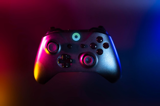 Jogador jogando o jogo online com controlador de joystick em neon glow dark cyberpunk room gaming e esports desafiam streamer de streaming de torneio com dispositivo analógico em casa