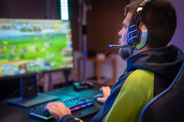Jogador jogando videogame online no computador em casa