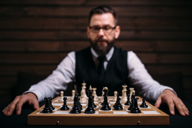 Jogador masculino contra tabuleiro de xadrez com conjunto de peças