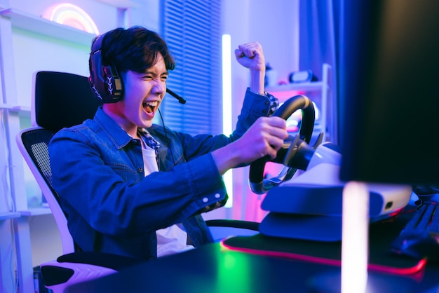 Jogador profissional asiático jogando um jogo de simulação de direção de carro online com controlador de volante Jogador ganhando um jogo de esports com emoção de vitória O jogador se alegra com a vitória na competição