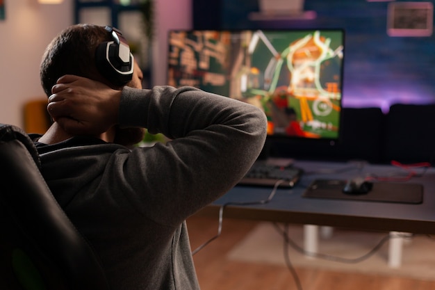 Jogador profissional jogando novos gráficos de videogame de tiro em um poderoso computador de casa. transmissão virtual online cibernética durante o torneio de jogo usando a tecnologia de rede sem fio
