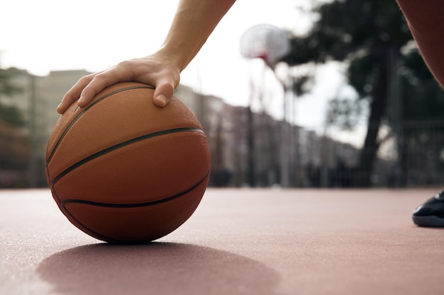 Jogador segurando a bola de basquete na quadra