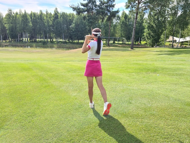 Jogadora de golfe profissional em roupas esportivas joga golfe no torneio de prática de golfe