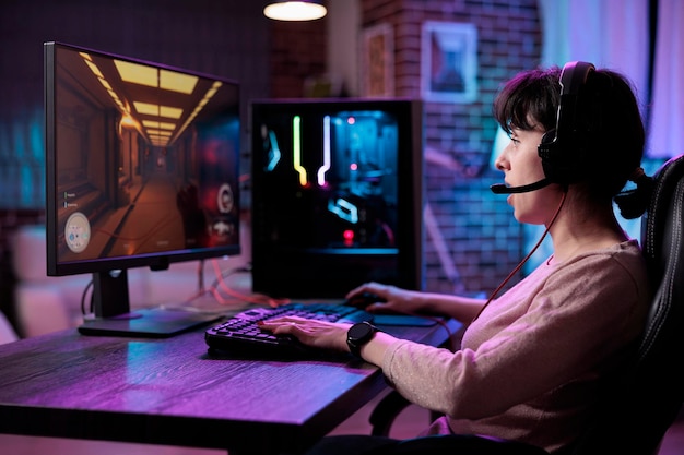 Jogadora se divertindo com a competição de videogames de ação, jogando campeonato de jogos online. Mulher caucasiana, desfrutando de torneio de jogo de rpg na transmissão ao vivo, jogos no computador.