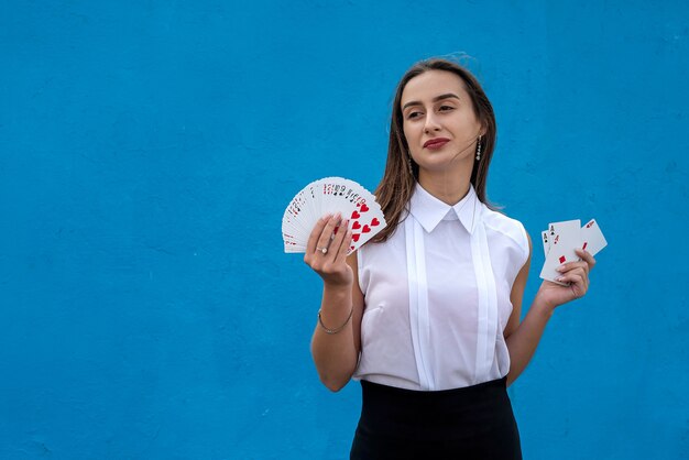 Jogadora segurando cartas de pôquer isoladas sobre fundo azul. jogo