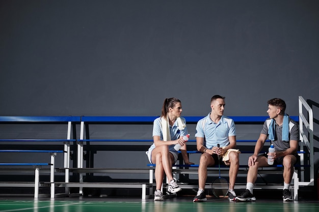 Jogadores de badminton descansando no banco