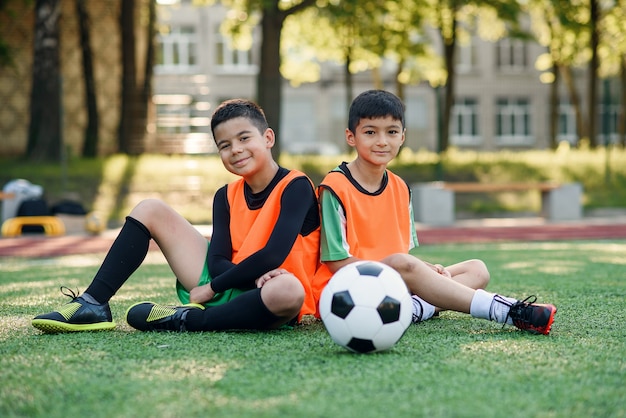 jogadores de futebol adolescentes descansando na grama artificial