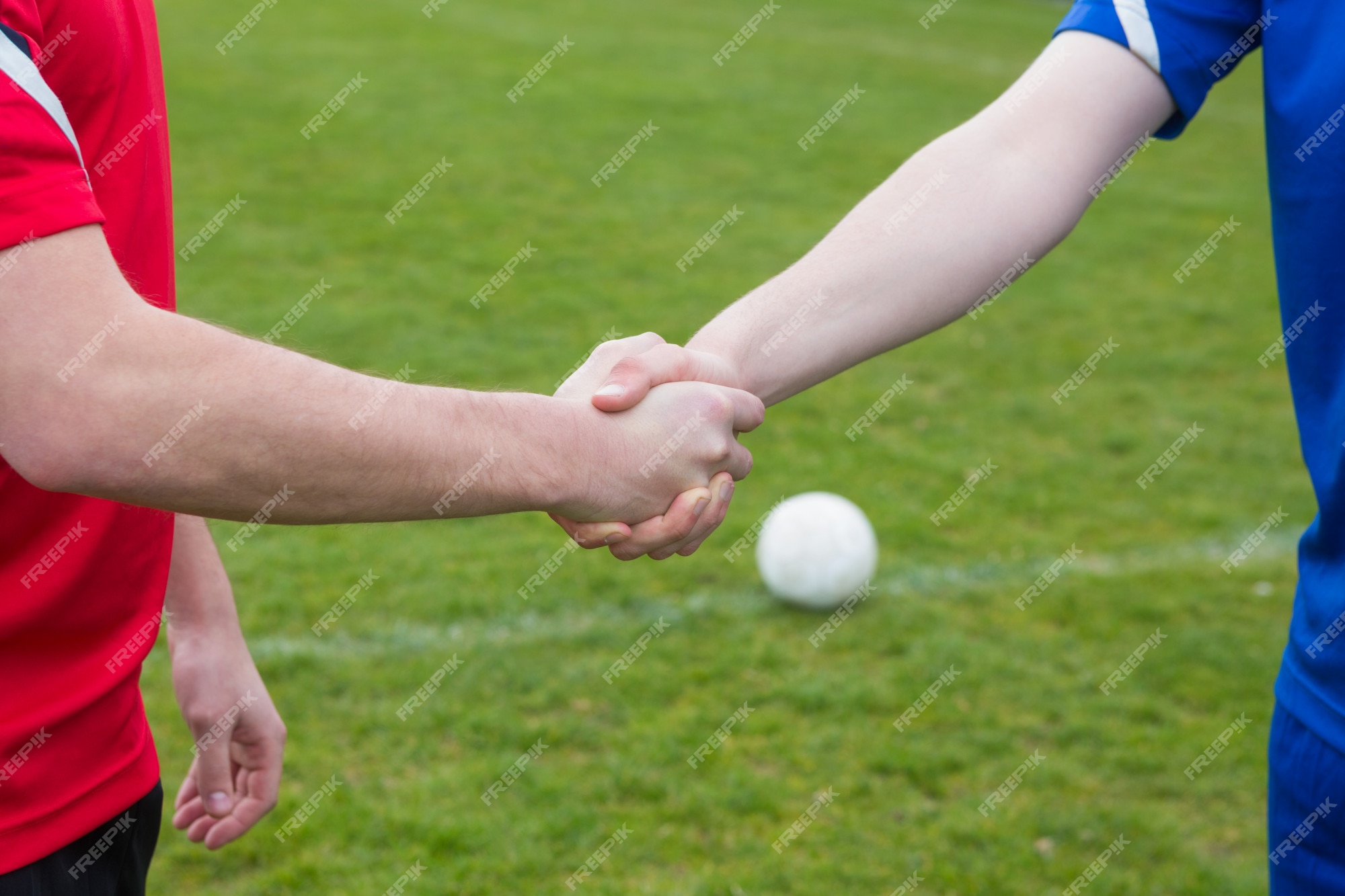 Foto Duas pessoas apertando as mãos em um jogo de campo de futebol – Imagem  de Futebol grátis no Unsplash