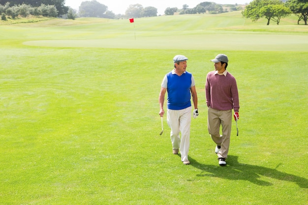 Jogadores de golfe amigos andando e conversando