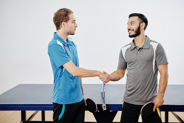 Jogadores de tênis de mesa apertando as mãos