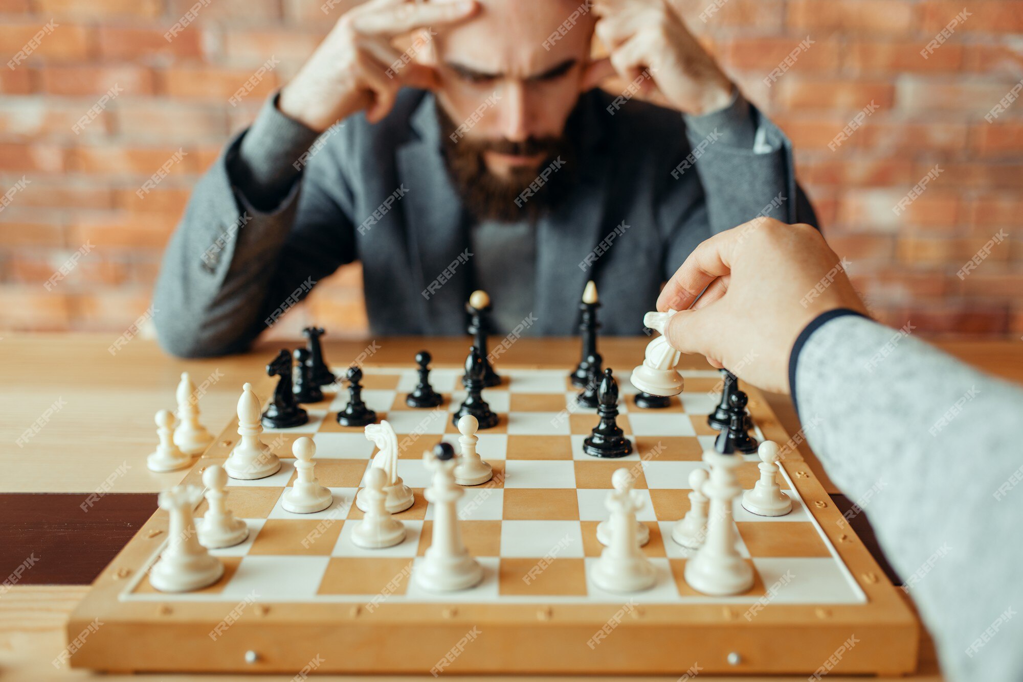 Jogadores de xadrez masculinos no tabuleiro, movimento de vista superior  branca. dois jogadores de xadrez começam o torneio intelectual dentro de  casa. tabuleiro de xadrez na mesa de madeira