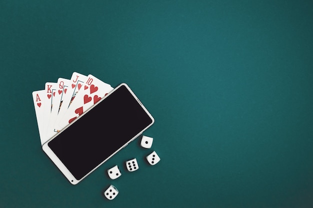 Jogando cartas de pôquer dados e telefone em tecido azul verde