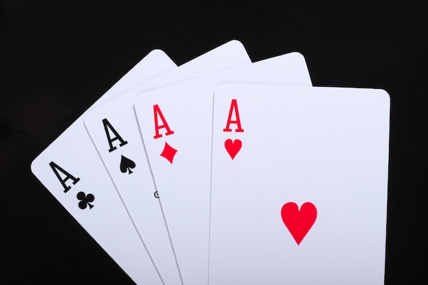 Jogando cartas de quatro ases no preto