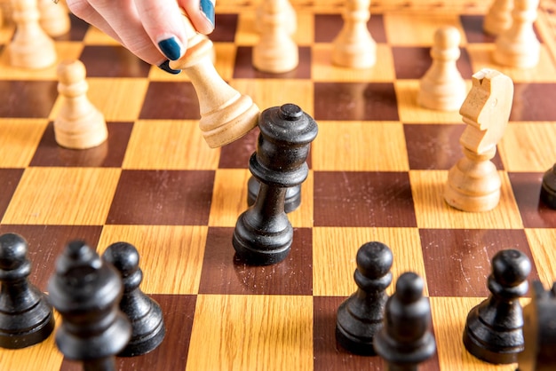 Jogando xadrez em um jogo de xadrez de estratégia de tabuleiro de madeira