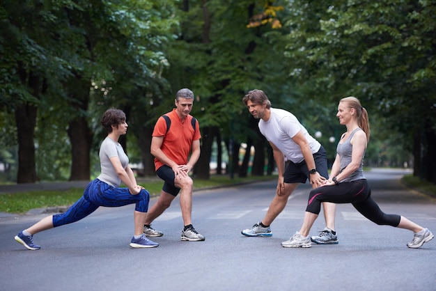 joggende menschengruppe, die sich vor dem training im park dehnt