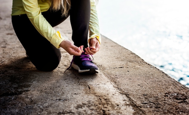 Jogger em uma pausa, amarrando o cadarço