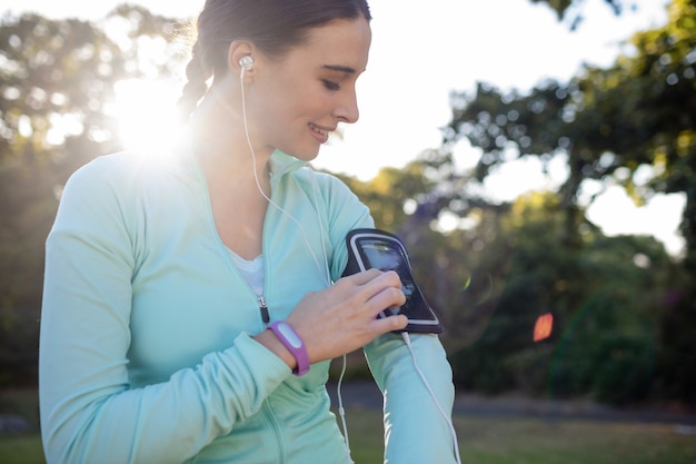 Jogger mujer escuchando música en el teléfono móvil