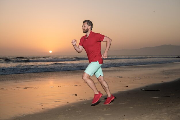 Jogger-Sportler läuft schnell, um bei Sonnenuntergang am Morgen zu gewinnen. Gesunder Mann läuft