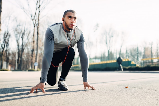 Jogger vor dem Laufen, aktiver, gesunder Lebensstil. Athlet am Morgen Fitness-Training. Läufer in Sportbekleidung beim Training im Freien