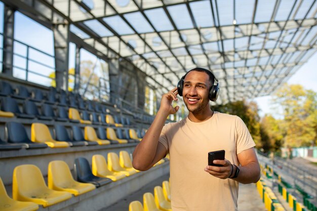 Jogging matutino ejercicios estilo de vida saludable joven hispano haciendo deporte en el estadio de pie