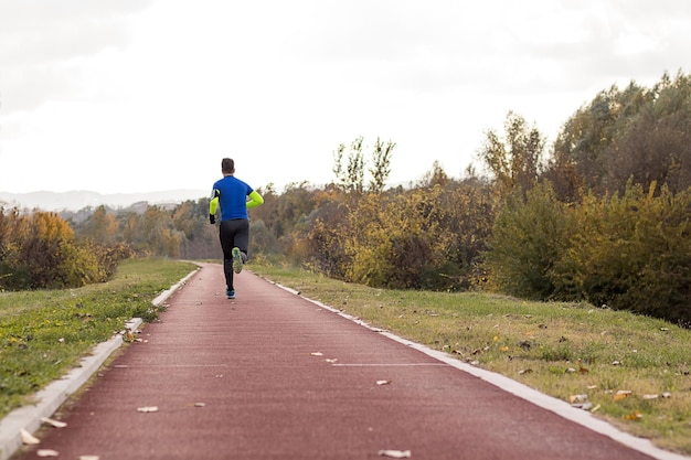 Jogging no parque Autumn Edition. Jovem em roupas esportivas correndo no parque