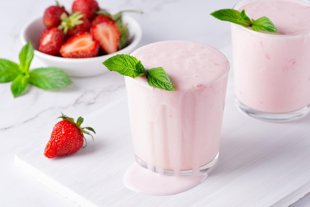 Joghurt-Buttermilch oder Kefir mit Erdbeerjoghurt im Glas auf hellem Hintergrund