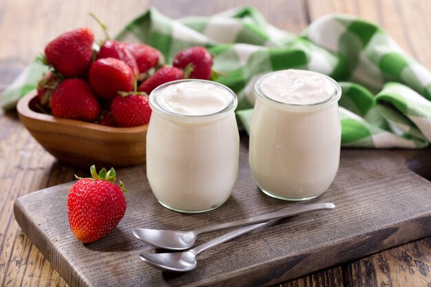 Joghurt in einem Glas mit frischen Erdbeeren auf Holztisch