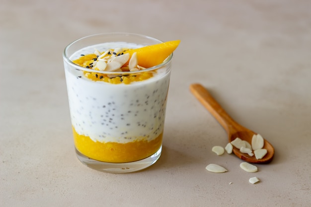 Joghurt in einem Glas mit Mango, Chia und Mandeln. Gesundes Essen. Vegetarisches Essen. Rezept. Frühstück. Diät.