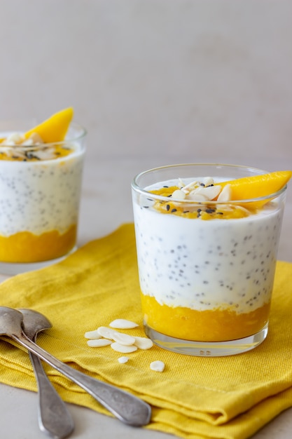 Joghurt in einem Glas mit Mango, Chia und Mandeln. Gesundes Essen. Vegetarisches Essen. Rezept. Frühstück. Diät.