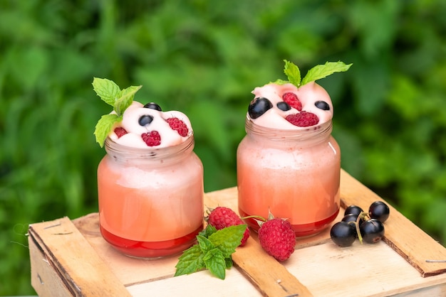 Joghurt mit Beeren zum Frühstück. Mit Himbeeren, Johannisbeeren und Blaubeeren.