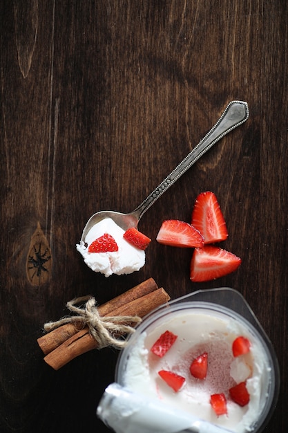 Joghurt mit frischen saftigen Erdbeeren und Kirschen auf einem Holztisch