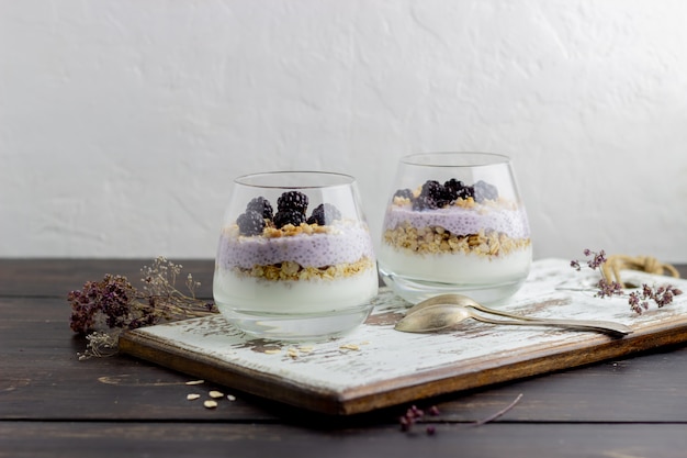 Joghurt mit Müsli, Chiasamen und Brombeeren auf einem hölzernen Hintergrund.