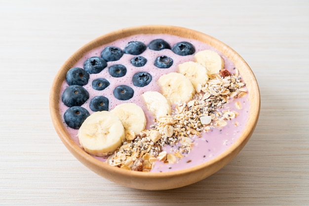Joghurt oder Joghurt-Smoothie-Schüssel mit blauen Beeren, Bananen und Müsli - Gesunde Ernährung