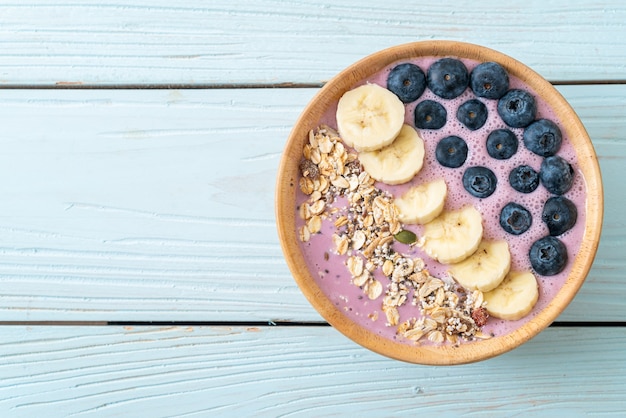 Joghurt oder Joghurt-Smoothie-Schüssel mit blauen Beeren, Bananen und Müsli - Gesunde Ernährung