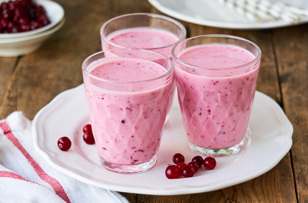 Joghurt-Smoothies mit frischen Preiselbeeren auf einem Holz